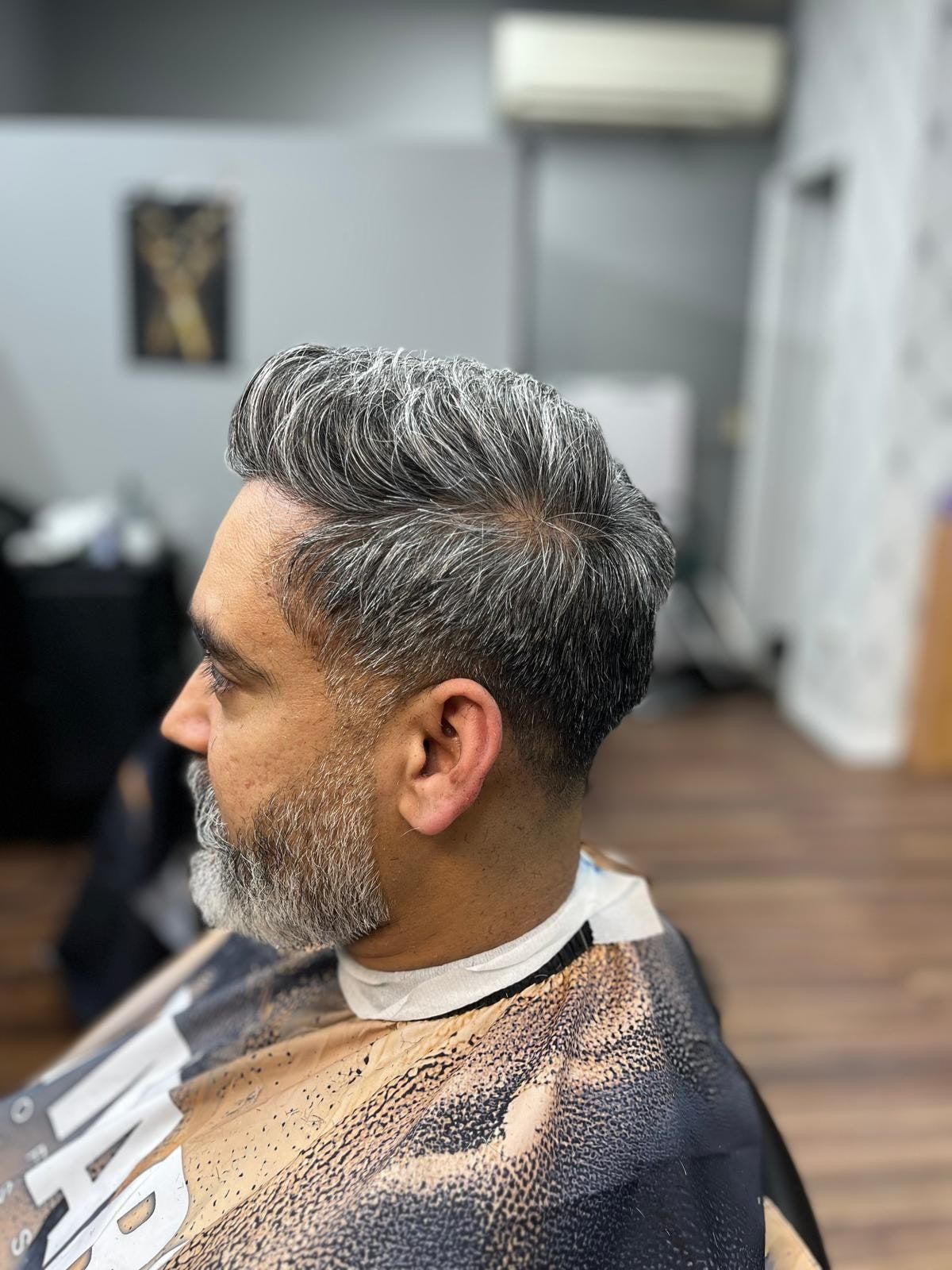 Salt-and-pepper textured quiff with tapered sides and a grey beard