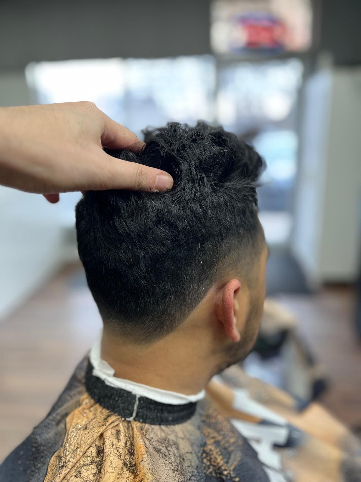 Curly textured top with a skin fade, seen from behind