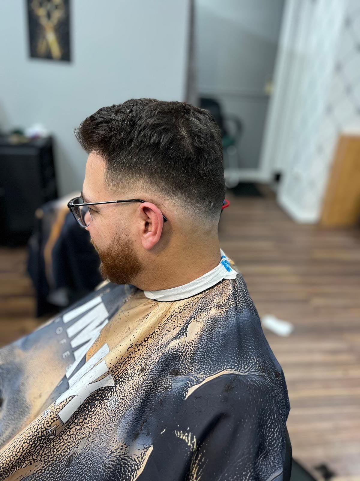 Textured top with a drop fade and a full beard